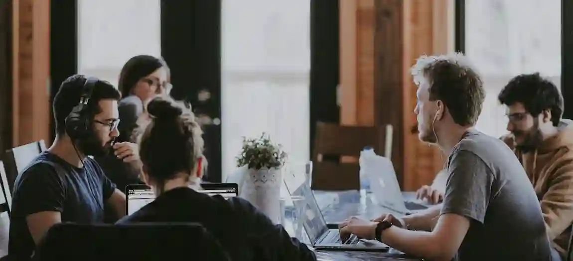 Group of people programming at a large table