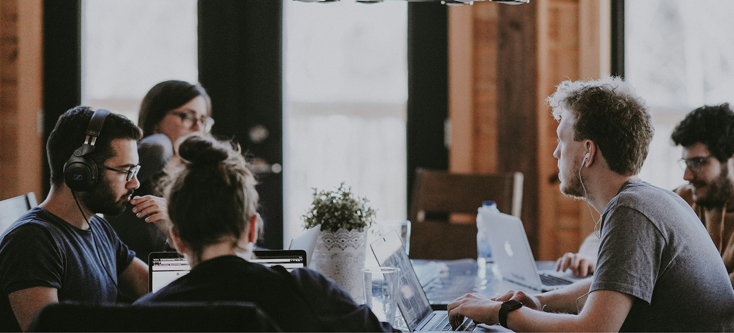 Group of people programming at a large table